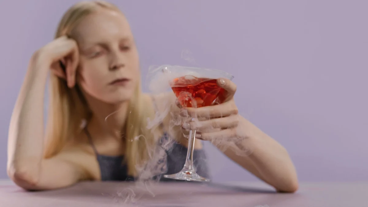 Een elegante vrouw met een spookachtige rokende cocktail, perfect voor Halloween-thema's.