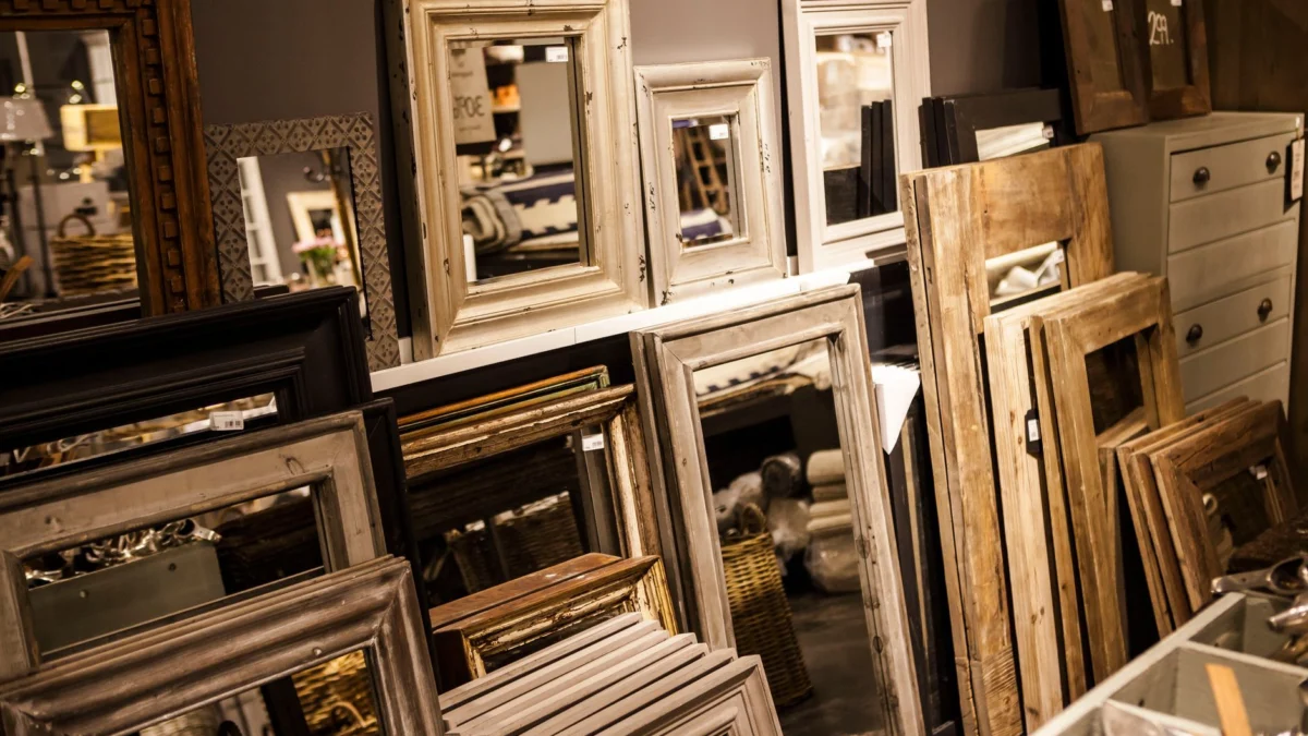 Een verzameling vintage-stijl spiegel lijsten tentoongesteld in een gezellige interieurwinkel inrichting.
