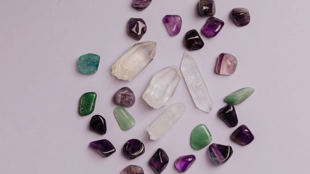 Een collectie van diverse edelstenen, waaronder amethist, jade en kwarts, netjes gerangschikt in een flat lay.