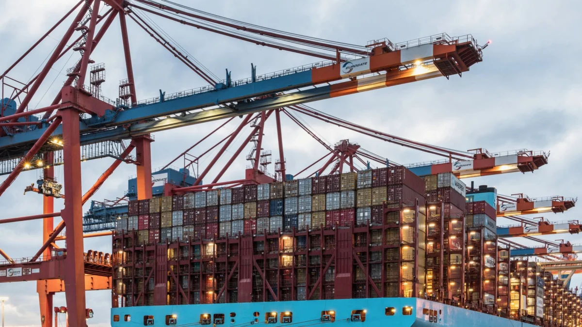 Een vrachtschip volgeladen met containers in de drukke commerciële haven van Hamburg.