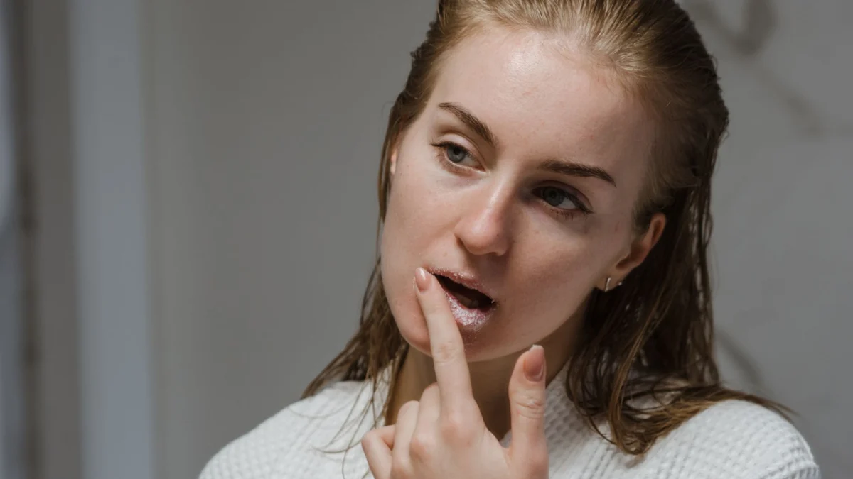 Volwassen vrouw brengt een lip scrub aan als onderdeel van haar beauty routine binnen.