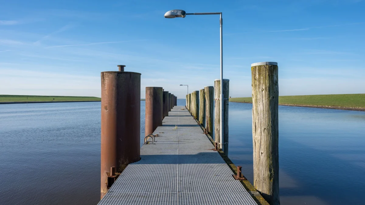 Een sereen uitzicht op een rustieke pier die uitsteekt in het kalme water van de Noordzee in Husum, Duitsland.