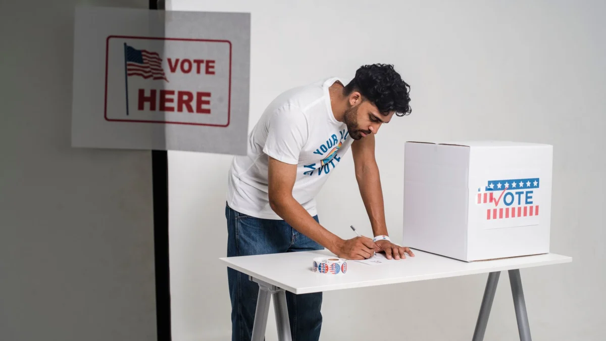 Een jonge man die op de verkiezingsdag stemt in een stembureau, wat democratie symboliseert.