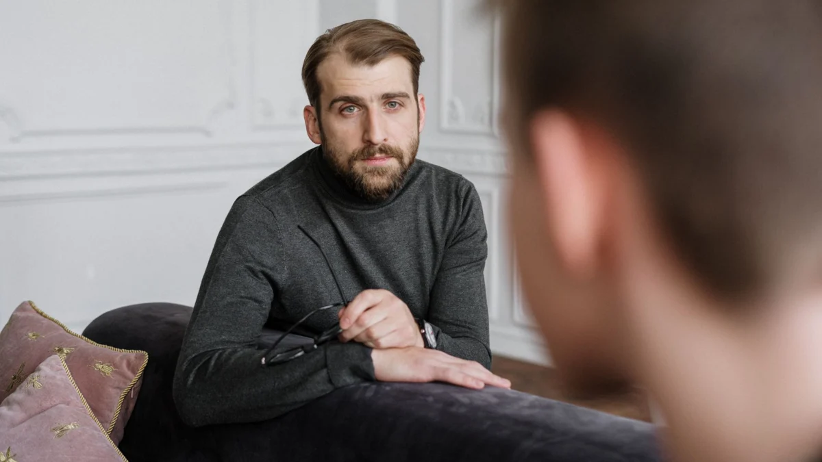 Een therapeut is in gesprek met een patiënt tijdens een gefocuste psychotherapie-sessie in een binnenomgeving.