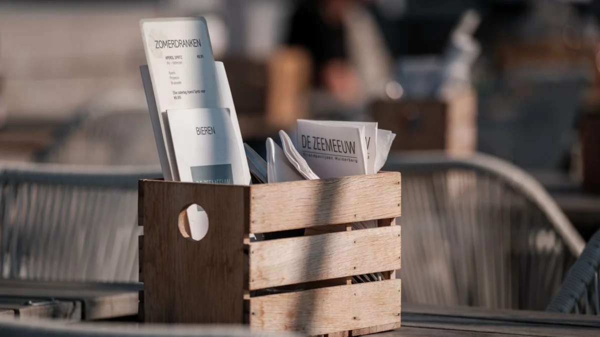 Zonnig terras met houten menukaart en gezellige sfeer.