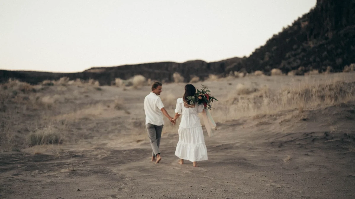 Stel hand in hand wandelend in een serene woestijnomgeving, vastleggend een romantisch moment.