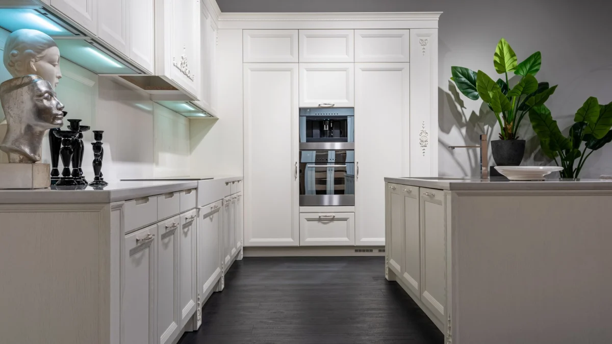 Stijlvolle witte keuken met planten en decoratieve elementen in een minimalistisch ontwerp.