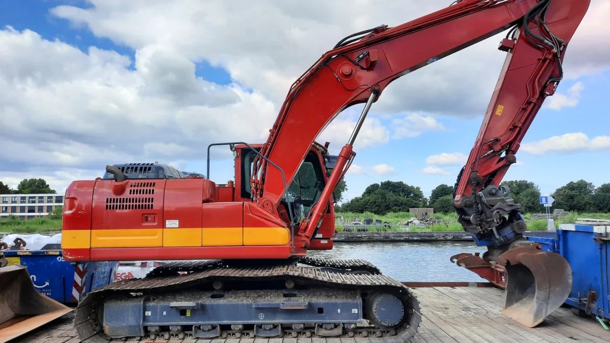 Rode graafmachine geparkeerd op een bouwterrein aan de rivier in Nederland.